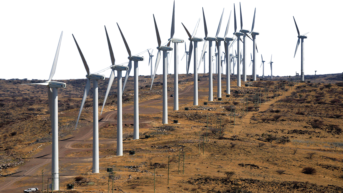 Wind turbines lining a road in an arid environment