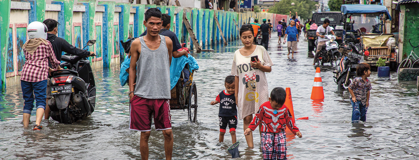 Photo of people walking through a flooded street