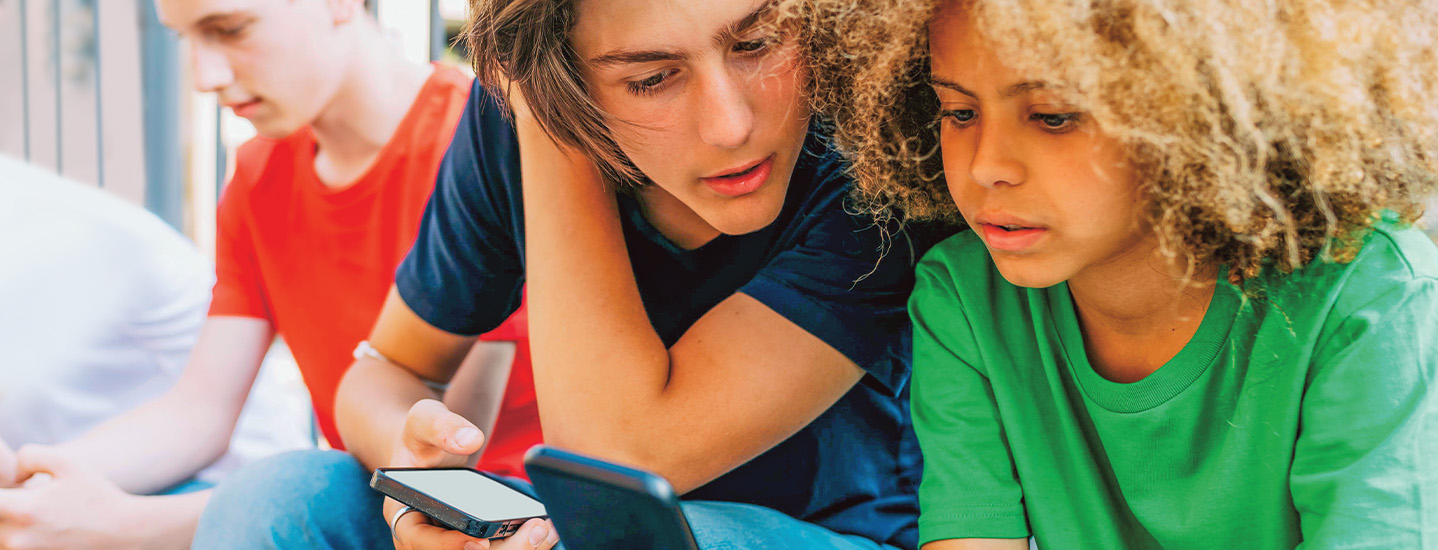 Image of three people sitting down and using their phones