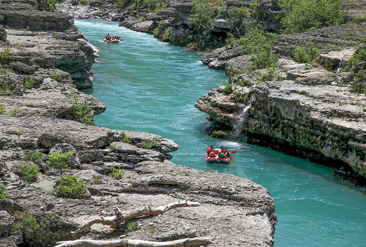 Bird&apos;s eye view of people water rafting down a river