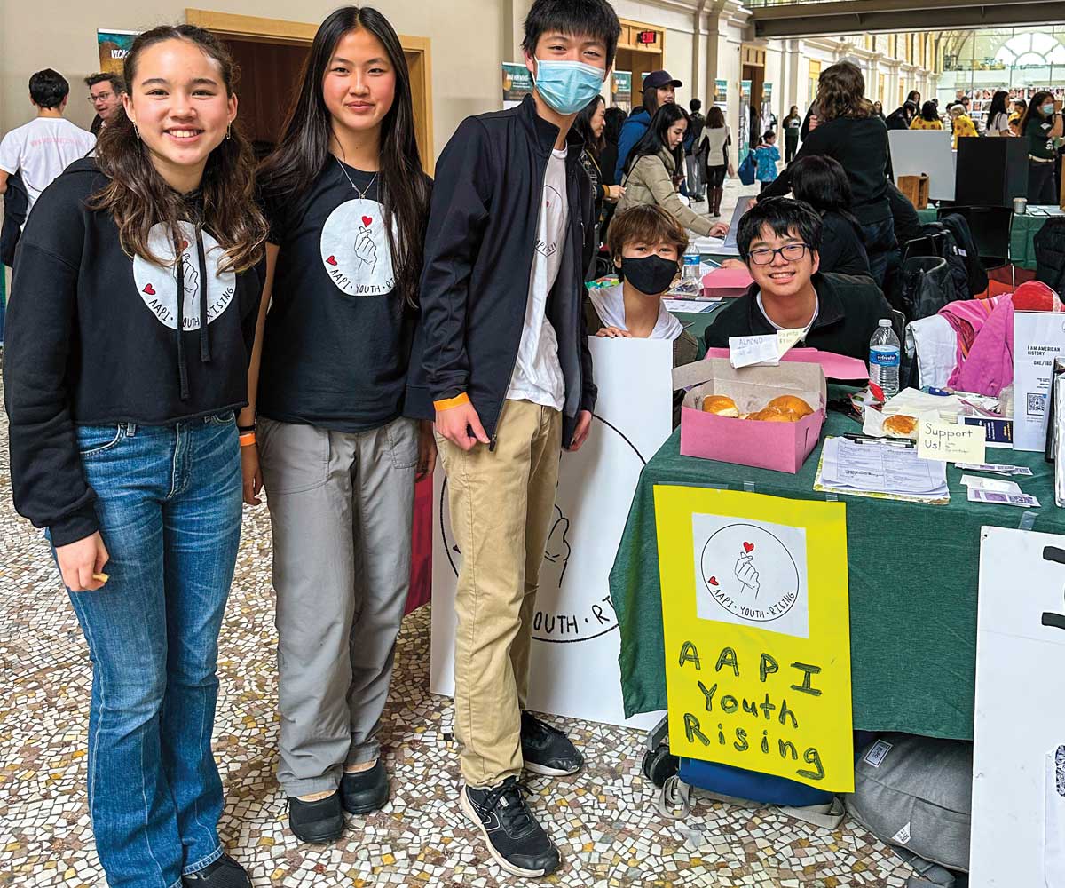 Photo of teens posing in front of a booth