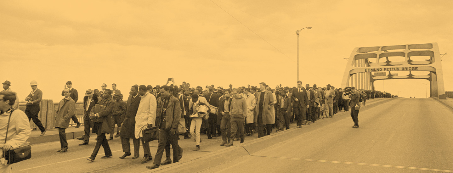 sepia photo of a large stream of demonstrators marching across the Edmund Pettus Bridge