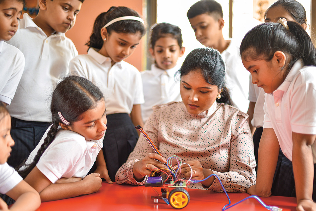 Teacher demonstrating an experiment while students are gathered around her